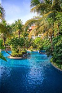 una piscina con palmeras y agua azul en Renaissance Sanya Haitang Bay Resort, en Sanya