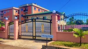 une maison dotée d'une porte avec un panneau devant elle dans l'établissement The Massango Guesthouse Limbe-Victoria Cameroon, à Limbe