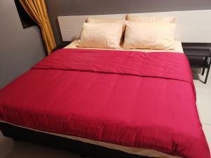 een bed met een rood dekbed en 2 kussens bij Belle Vue 408 Genting View Resort in Genting Highlands +18 foto's