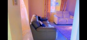 a living room with a couch and two chairs at The Massango Guesthouse Limbe-Victoria Cameroon in Limbe