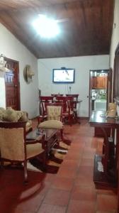 ein Wohnzimmer mit Holzmöbeln und einem Tisch in der Unterkunft Finca Turística El quinto Elemento in San Vicente de Chucurí