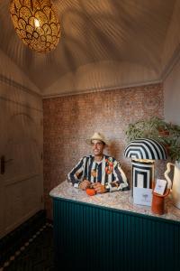 Un homme dans un chapeau assis au comptoir dans l'établissement Riad Botanica, à Marrakech