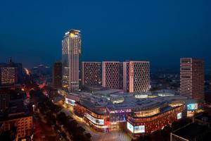 a city skyline at night with a tall building at Sheraton Zibo Hotel in Zibo