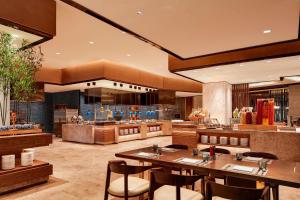 a restaurant with tables and chairs and a kitchen at Sheraton Zibo Hotel in Zibo