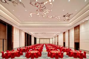 淄博淄博喜来登酒店 的摆放着红色桌椅的大型宴会厅