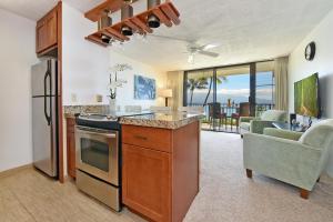 a kitchen and living room with a view of the ocean at Maalaea Banyans 203 in Wailuku