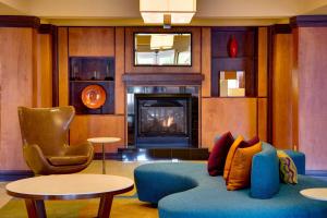 a living room with a blue couch and a fireplace at Fairfield by Marriott Inn & Suites Melbourne West/Palm Bay in Melbourne