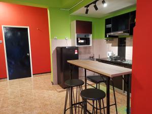 een keuken met groene en rode muren en een houten tafel bij Belle Vue 408 Genting View Resort in Genting Highlands