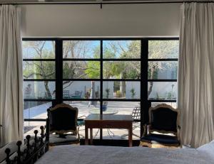 sypialnia z dużym oknem ze stołem i 2 krzesłami w obiekcie Beautiful artist's suite w full bath kitchenettte w mieście Tucson