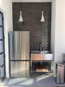 kuchnia z lodówką ze stali nierdzewnej i zlewozmywakiem w obiekcie Beautiful artist's suite w full bath kitchenettte w mieście Tucson
