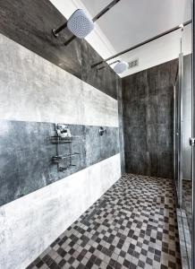 a bathroom with a shower and a checkered floor at Tarkshay Hospitality in Densainagar