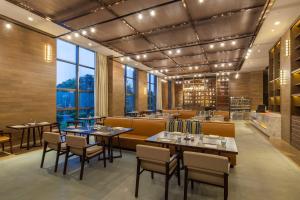 a restaurant with tables and chairs and a large window at Four Points by Sheraton Hefei, Baohe in Hefei