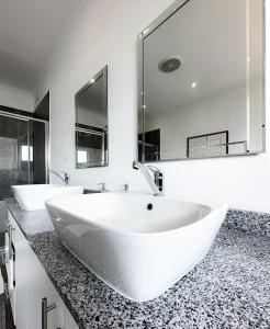 a bathroom with two sinks and a large mirror at Tarkshay Hospitality in Densainagar