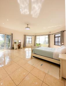 a large bedroom with a bed and a tiled floor at Tarkshay Hospitality in Densainagar