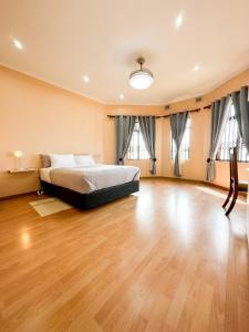 um quarto com uma cama e piso em madeira em Tarkshay Hospitality em Densainagar