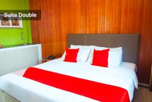 a bedroom with a large bed with red pillows at Hotel Kristal, Keningau in Keningau