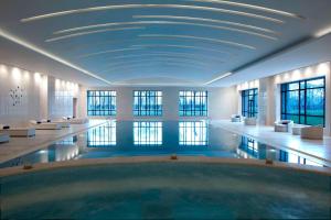 a swimming pool in a building with a blue ceiling at Marriott Executive Apartment Tianjin Lakeview in Tianjin