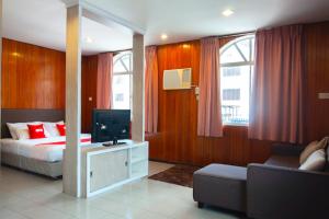 a bedroom with a bed and a tv and a couch at Hotel Kristal, Keningau in Keningau