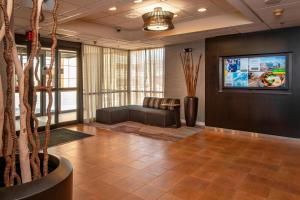 eine Lobby mit einem Sofa und einem TV an der Wand in der Unterkunft Courtyard Wilmington Downtown in Wilmington