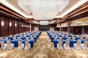 une salle de conférence avec des chaises et un grand lustre dans l'établissement Courtyard by Marriott Wuxi Lihu Lake, à Wuxi