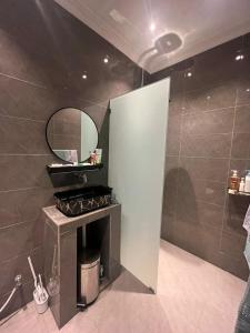 a bathroom with a fireplace and a mirror on the wall at Marimar Stayz Tandop in Alor Setar +5 photos