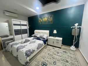 a bedroom with a bed and a blue wall at Marimar Stayz Tandop in Alor Setar