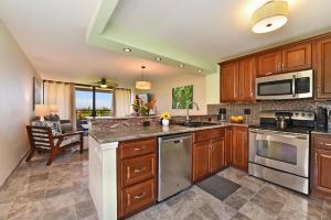 a kitchen with wooden cabinets and stainless steel appliances at Kahana Villa E601 in Kahana