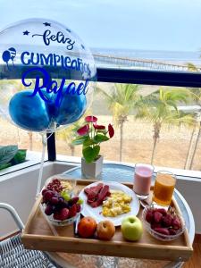 una bandeja de comida para el desayuno en una mesa con un globo en ADDA Pacasmayo, en Pacasmayo