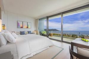 a bedroom with a large white bed and a large window at The Westin Blue Bay Resort & Spa in Lingshui