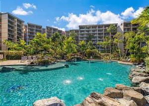 a swimming pool in front of a large building at Kaanapali Shores 836 in Kahana