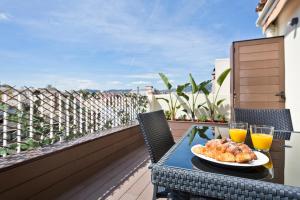 a table with a plate of food and two glasses of orange juice at Stay U-nique Apartments Rambla Catalunya IV in Barcelona