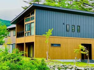 a house with a blue and wooden facade at Chalet Setsugekka in Hakuba