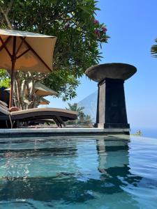 a swimming pool with a bird bath next to the water at The Puncak Lombok in Senggigi