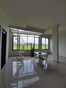 - un salon avec une table, des chaises et des fenêtres dans l'établissement Gemintang Home at Bukit Gardenia Resort, à Tarogong