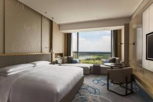 蘇州市にあるSuzhou Marriott Hotel Taihu Lakeのベッドと大きな窓が備わるホテルルームです。