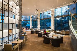 een restaurant met tafels en stoelen en grote ramen bij Suzhou Marriott Hotel Taihu Lake in Suzhou