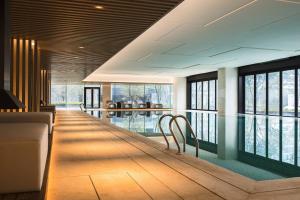 Zimmer mit einem Pool mit Stühlen und Fenstern in der Unterkunft Suzhou Marriott Hotel Taihu Lake in Suzhou
