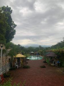 a resort with a swimming pool with a person in the background at Layugan garden resort bucay abra in Bangued