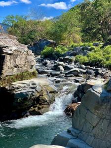 un fiume con rocce e una montagna sullo sfondo di Layugan garden resort bucay abra a Bangued
