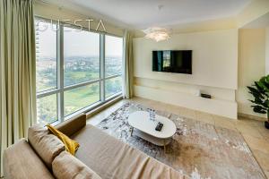 a living room with a couch and a large window at Fairways Tower by Emaar, The Views and Greens in Dubai