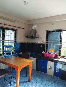 uma cozinha com uma mesa de madeira e uma sala de jantar em Namaste Stay Apartment em Pokhara