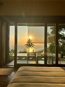 a bedroom with a bed and a view of the ocean at The Puncak Lombok in Senggigi