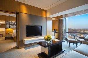 a living room with a television and a living room with a couch at Renaissance Beijing Wangfujing Hotel in Beijing