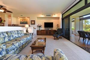 a living room with a couch and a tv at Kaanapali Royal N102 in Lahaina