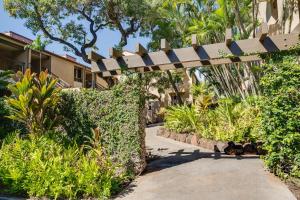a pathway through a garden with a pergola at Kaanapali Royal N102 in Lahaina