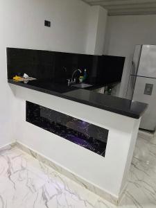 a kitchen with a black counter and a sink at CASA DEL ARBOL in Doradal