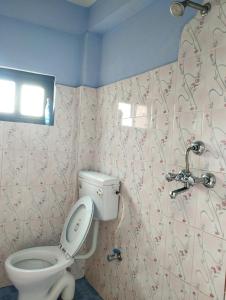 uma casa de banho com um WC e um chuveiro em Namaste Stay Apartment em Pokhara