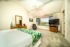 a bedroom with a bed and a flat screen tv at Kaanapali Royal B303 in Lahaina