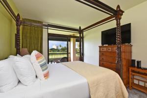 a bedroom with a bed with a dresser and a television at Kaanapali Royal C202 in Lahaina