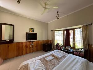 a bedroom with a bed and a flat screen tv at IVY The Boutique Hotel By Sukhmani Resorts in Nainital